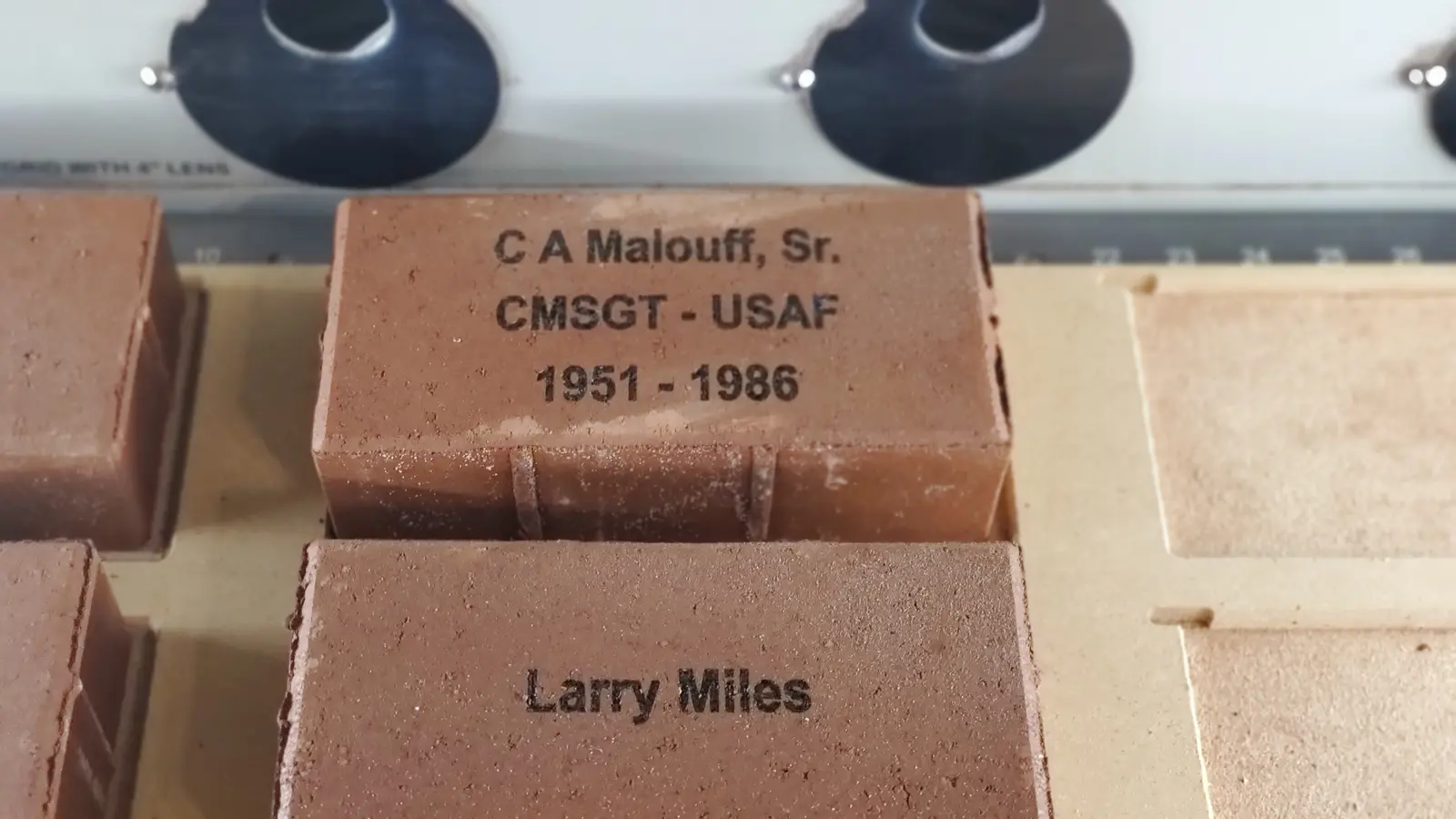 Memorial pavers being laser engraved in repeat production